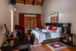 焦济尼Ndumu River Lodge的一间卧室配有一张床、一张书桌和一张书桌