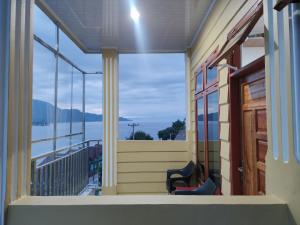 图克图克Tama View的阳台配有两把椅子,享有水景