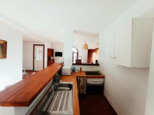马拉加Apartamento en Villa con Piscina的厨房配有白色橱柜和木制台面