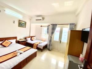 头顿Ngoc dung MoTel的客房设有两张床、一张沙发和一台电视。