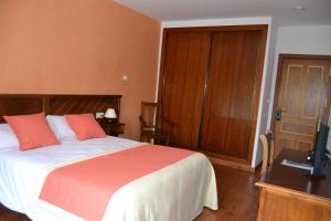 El AlmiceránHotel Rural Ibipozo的一间卧室配有一张床和一张书桌及电视