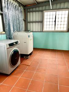 马公澎湖菊舍民宿一館的客房设有洗衣机和瓷砖地板。