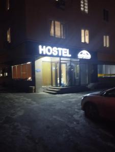 阿拉木图KOCHEVNIK HOSTEL的医院标志的建筑在晚上点亮
