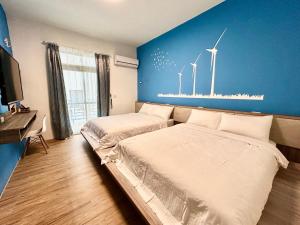 马公澎湖菊舍民宿一館的卧室配有两张挂在墙上的风车床。