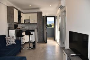 安塔利亚STELLA APART-SUIT HOTEL -All Inclusive-的一间带蓝色沙发的客厅和一间厨房