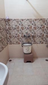 AyodhyaARJUN PAYING GUEST HOUSE的角落里带卫生间的浴室,配有壁纸