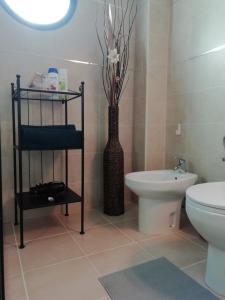 普拉亚布兰卡Villa Pura Vida的一间带卫生间和花瓶的浴室