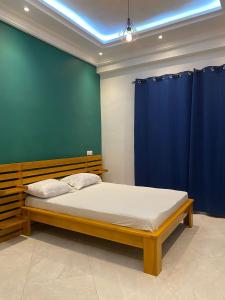 科托努Residence SIRTAK的一间卧室配有一张蓝色墙床