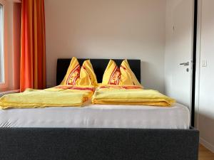 安嫩海姆Villa Winkler的一张带黄色毯子和枕头的床
