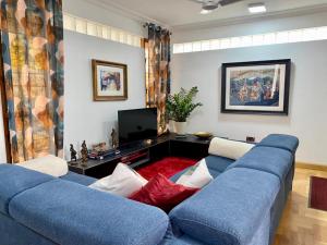 KwashiemanInviting 3-Bed House in Awoshie Accra的客厅配有蓝色的沙发和电视