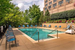 切斯特菲尔德圣路易斯西万豪酒店的一座带蓝色椅子的游泳池和一座建筑