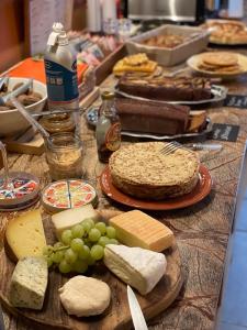 那慕尔STUDIO VUE SUR MEUSE的餐桌上放着奶酪和葡萄,还有蛋糕