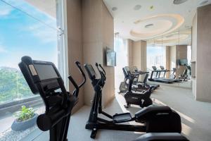 布巴内什瓦尔LYFE HOTEL的健身房,设有数排跑步机和椭圆机