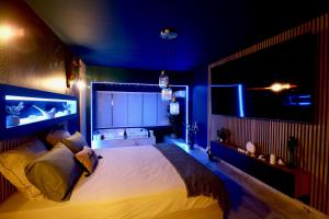 滨海拉塞讷Flower Suite and Spa的一间卧室配有一张蓝色灯的大床
