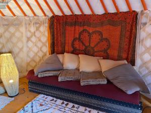 布瓦乐洛伊Les Hôtes de Sermaize的帐篷内的一张床位,配有枕头和地毯