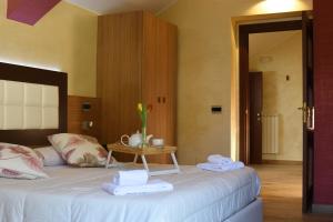 卡普拉科塔Hotel Monte Campo的一间卧室配有一张床、一张桌子和毛巾