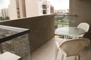 科尔多瓦Cordoba Rent Centro Avellaneda的大楼内的阳台配有玻璃桌和椅子