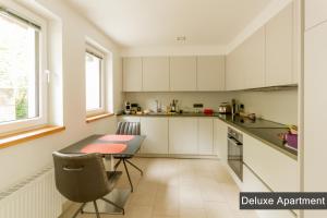 锡默拉特Rurtal de luxe的厨房配有白色橱柜和桌椅