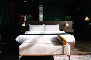 华欣华欣海魁特花园酒店的一间卧室配有一张大床和木制床头板