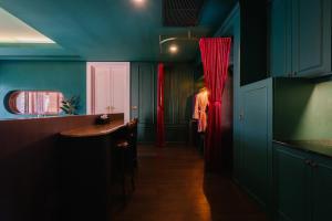 华欣华欣海魁特花园酒店的厨房设有蓝色的墙壁和红色的窗帘