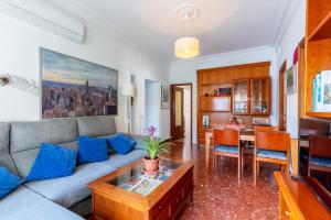 塞维利亚特里亚纳洛斯雷梅迪奥斯公寓的客厅配有沙发和桌子
