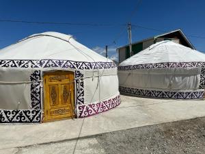 奥尔吉Traditional Yurts - Ulgii Guest House的两顶大地测量帐篷,里面设有黄色门
