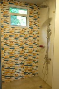 卡迪克兰VIEDA HOTEL的一间带淋浴的浴室和瓷砖墙