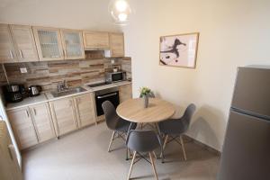 科扎尼Newly Renovated Central 2 Bedroom Apartment in Kozani的一个带木桌和椅子的小厨房