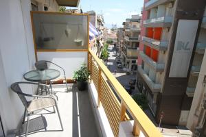 科扎尼Newly Renovated Central 2 Bedroom Apartment in Kozani的阳台配有桌椅和街道。