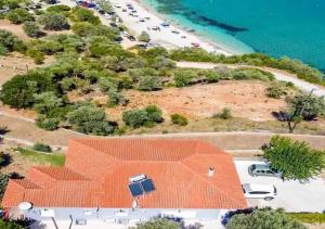 PetriaíAegean Beachfront House的享有橙色屋顶和海滩的空中景致