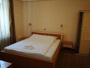 图兹拉Motel Royal的一间卧室配有一张床,上面有两条毛巾