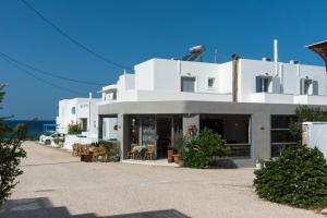 阿波罗尼亚V-rooms in Milos Cyclades的前面有桌椅的白色建筑