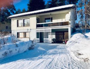 艾内科斯基Detached house Mämmensalmi的雪中带车道的房子