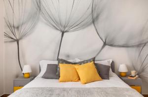 米兰The House of Dandelions - Duomo in 15min by metro M3的一间卧室配有一张带灰色和黄色枕头的床