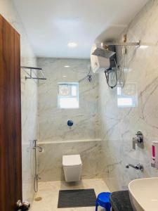 德奥加尔HOTEL MAA LAXMI PALACE的带淋浴、卫生间和盥洗盆的浴室