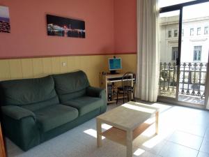 巴塞罗那新科隆旅馆的客厅配有绿色沙发和桌子