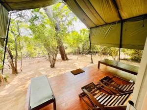 雅拉Green Wild Yala - Luxury Camping & Free Safari Tour的门廊上设有桌椅,