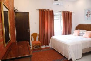 科伦坡Palm Grove的卧室配有1张床、1张桌子和1把椅子