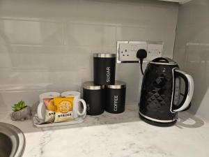 钱德勒福德Brand New Private Annex Guest Suite的厨房柜台,配有2个咖啡杯和咖啡机