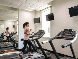 迪拜宜必思中央一号酒店 - 迪拜世界贸易中心的一名在健身房跑步机上跑步的女人