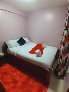 纳库鲁JAYDE COSSY HOMES的一间卧室配有一张带红色毯子的床