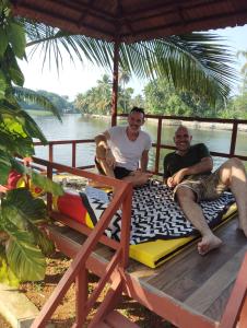 阿勒皮The Lake Paradise Boutique Resort的两个人坐在船上的床上