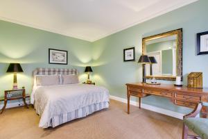 卡尔斯Glen Isla House Bed & Breakfast Phillip Island的一间卧室配有一张床、一张书桌和一面镜子