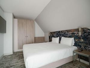 锡比乌Mercure Sibiu Arsenal的卧室配有一张白色大床和电视。