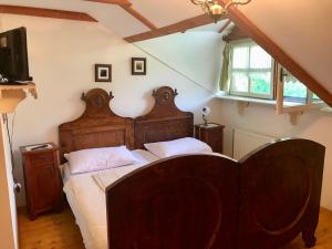Mokrinetno kuća Đeram的一间卧室配有一张大木床和白色床单