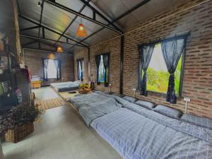 木州县Vườn Trên Mây - Skyline Farm & Homestay的一间卧室设有两张床和砖墙