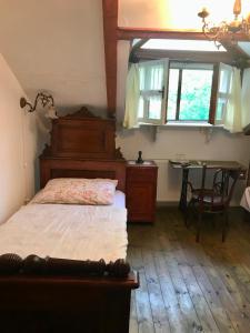 Mokrinetno kuća Đeram的一间卧室配有一张床、一张桌子和一个窗户。