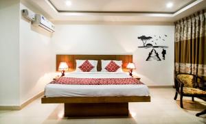 商沙巴Rainbow International Hotel Airport Zone Shamshabad的一间卧室配有一张大床和一把椅子