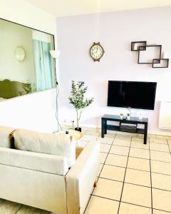 厄热涅莱班Le cocon的客厅配有白色沙发和电视