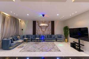 Al Harazatشاليهات الجوري的客厅配有蓝色的沙发和平面电视。